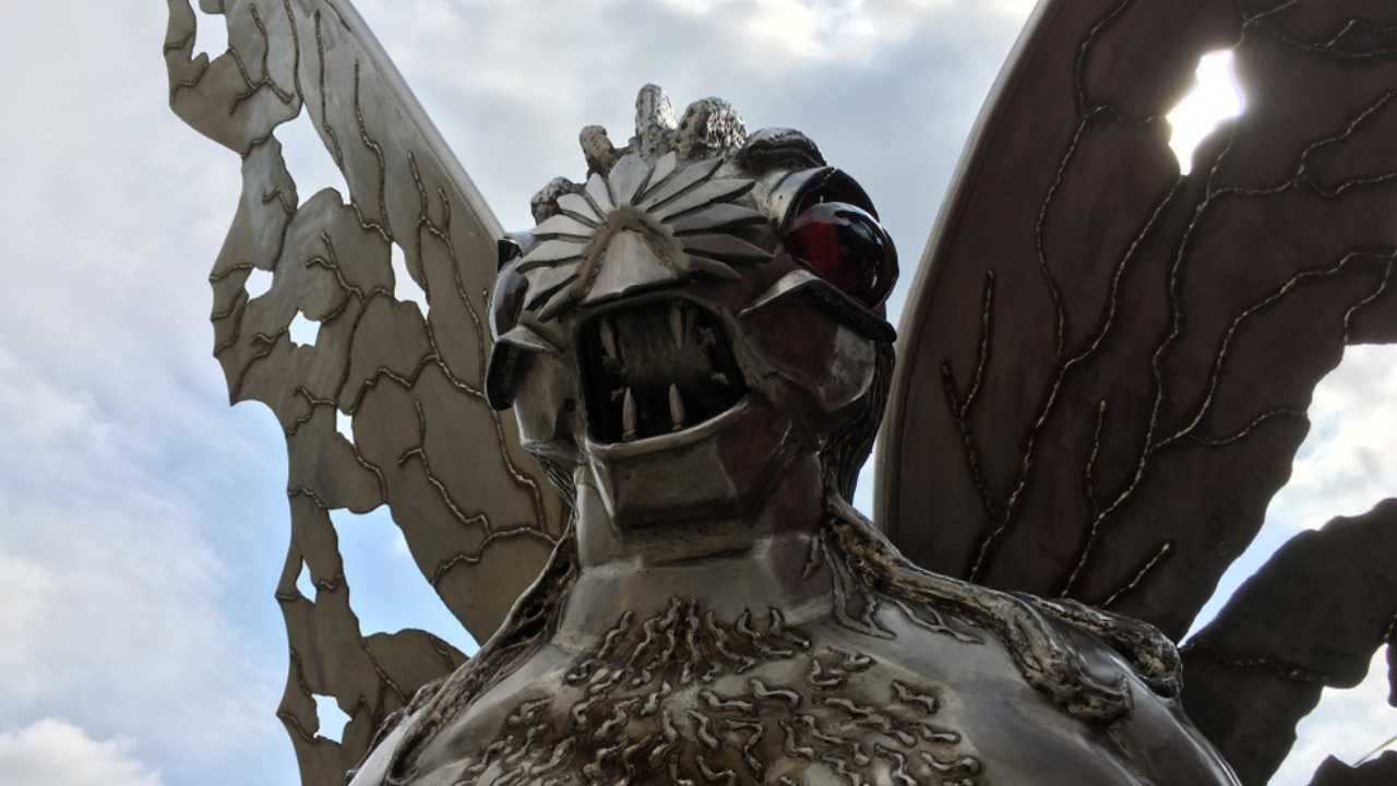 Point Pleasant, West Virginia / USA - September 2, 2019: Silver Mothman Statue Backlit on Cloudy Day