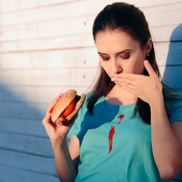 Woman eating messy food, stain on shirt