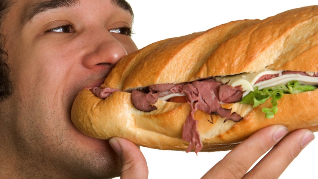 Man eating long size of subway sandwich